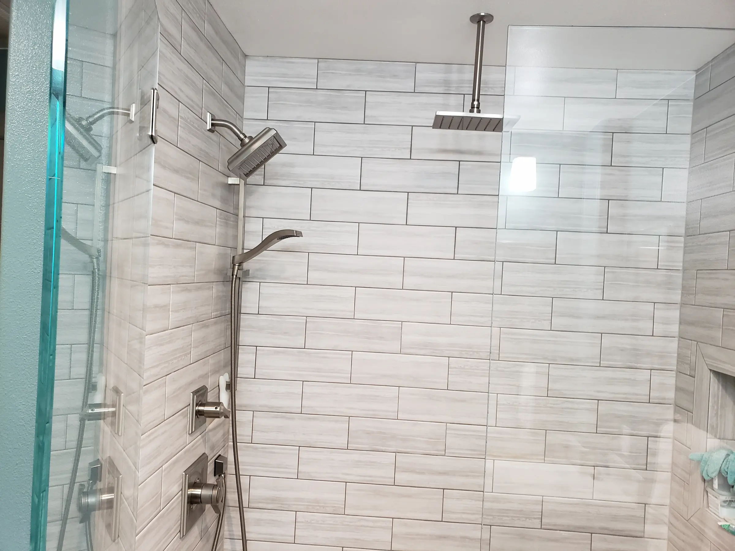 Modern shower with dual showerheads and glass door.