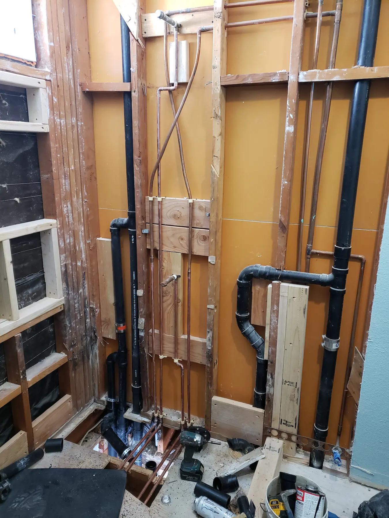 Exposed plumbing and framing in a bathroom under renovation.